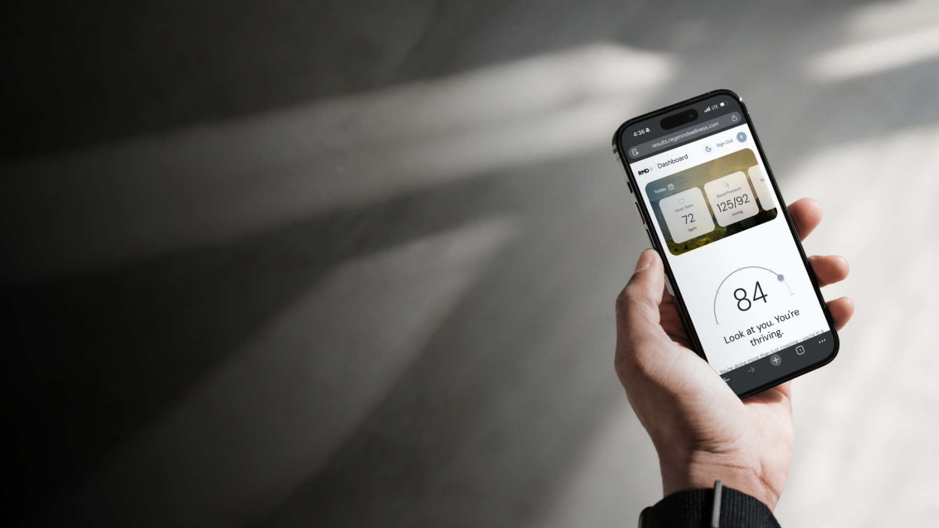 Hand holding a smartphone with an app displayed on a blurred background